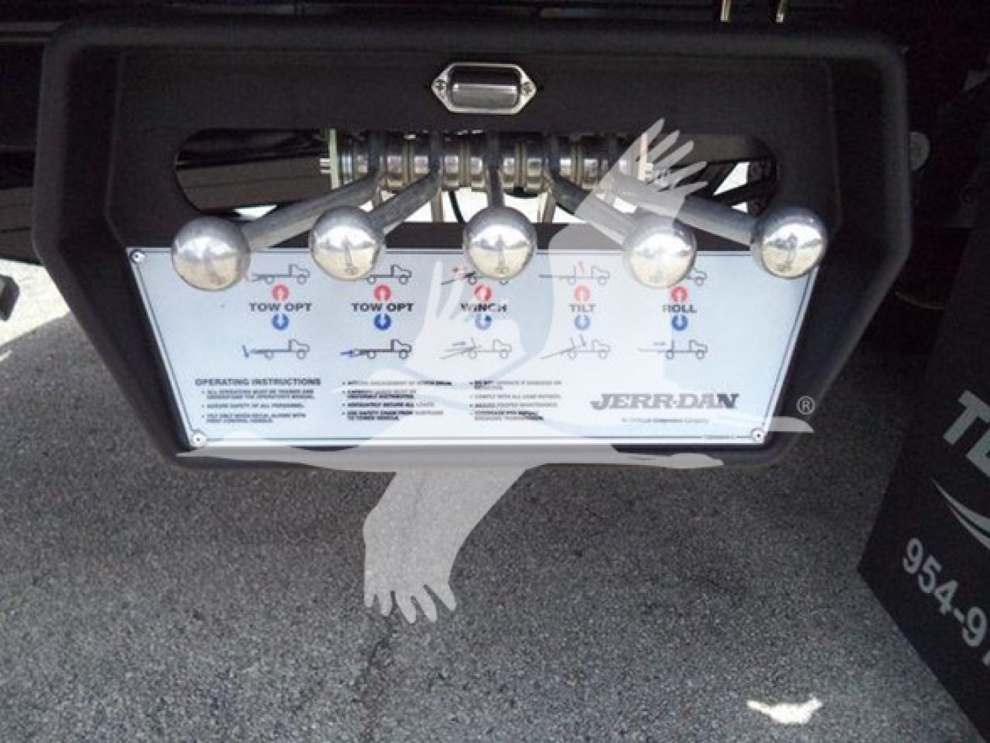 Trucks undercarriage control panel with multiple levers labeled for towing operations on a Jerr-Dan rollback unit, showing instruction panel and chrome levers.