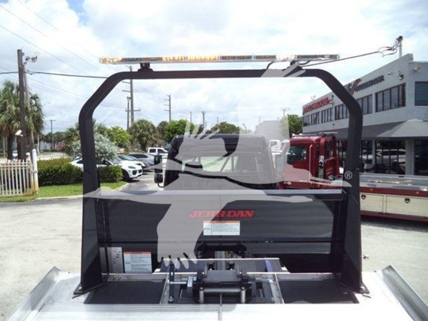 Freightliner M2 106 rollback truck interior view showing rear cargo area and mounting frame with operator’s seat visible, branding and utility rails.