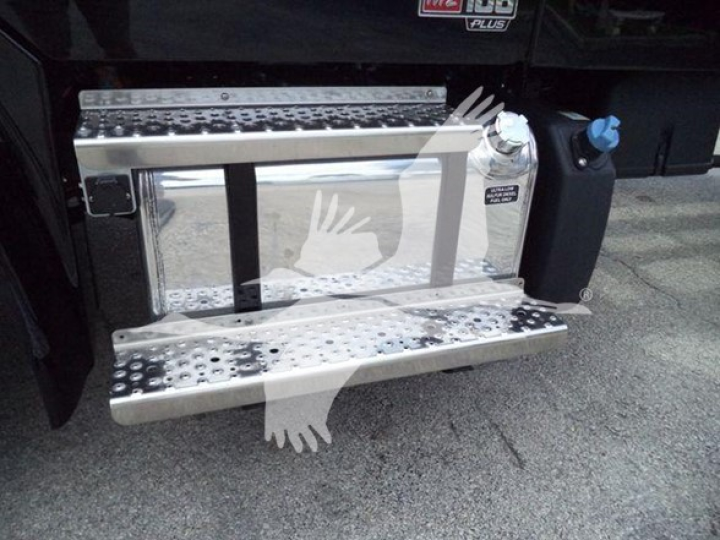 Truck side step with chrome fuel tank and black cab; visible steps and a blue cap near the running board.