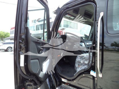 Truck cab interior view of a Freightliner M2 106, open door showing driver's seat and dashboard