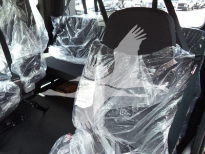 Truck cab interior showing plastic seat covers and driver's seat in new condition inside Freightliner M2 106 rollback.