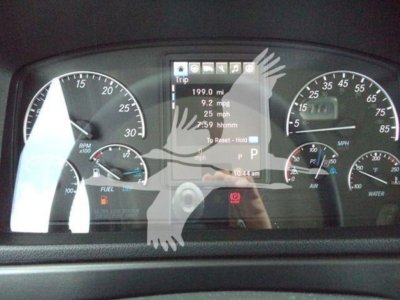 Dashboard display of a Freightliner M2 106 showing instrument cluster and digital trip data including 199.0 mi, 9.2 mpg, 25 mph, and P gear with tachometers and gauges.