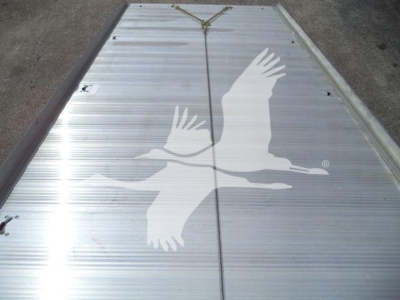 Flatbed or trailer deck with a large white gulls graphic on metal surface, center seam and chains visible.