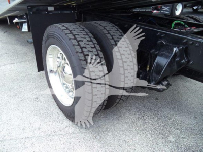 Dual rear wheels on a Freightliner M2 106 rollback truck showing tandem axle and suspension components.