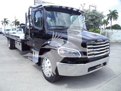 Freightliner M2 106 rollback truck front view showing chrome grille and black cab.