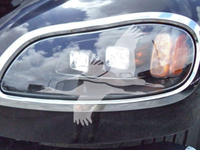 Front headlight assembly of a Freightliner M2 106 with four rectangular lights and amber turn signal arranged in a row.