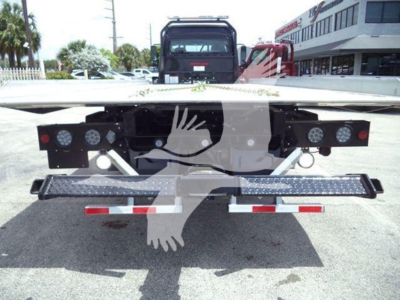 Truck rear view showing flatbed and bumper with multiple round lights and reflectors on Freightliner M2 106 rollback.
