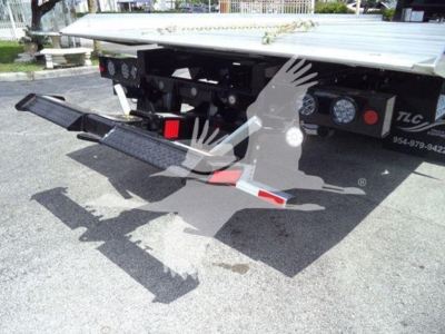 Freightliner M2 106 rollback truck rear view showing hydraulic ramps and toolbox with gauges, lights, and labels.