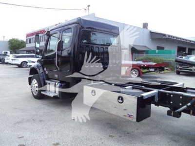 Flatbed rollback truck at dealership showing Freightliner M2 106 cab and chassis with side toolbox, black exterior, VIN 3ALACWFC3VDXD5067 visible on listing.