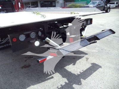 Freightliner M2 106 rollback truck rear with hydraulic stowaway step and controls visible under bed.