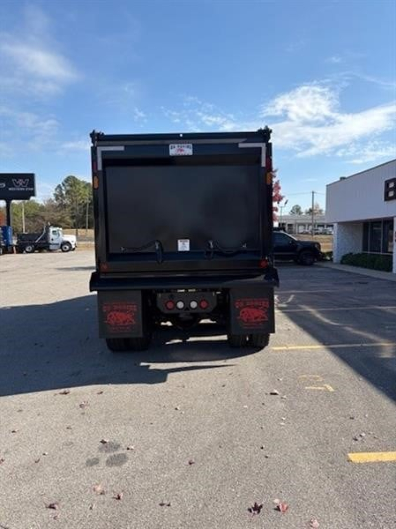 Dump truck rear showing hitch area and dump bed in folded position.
