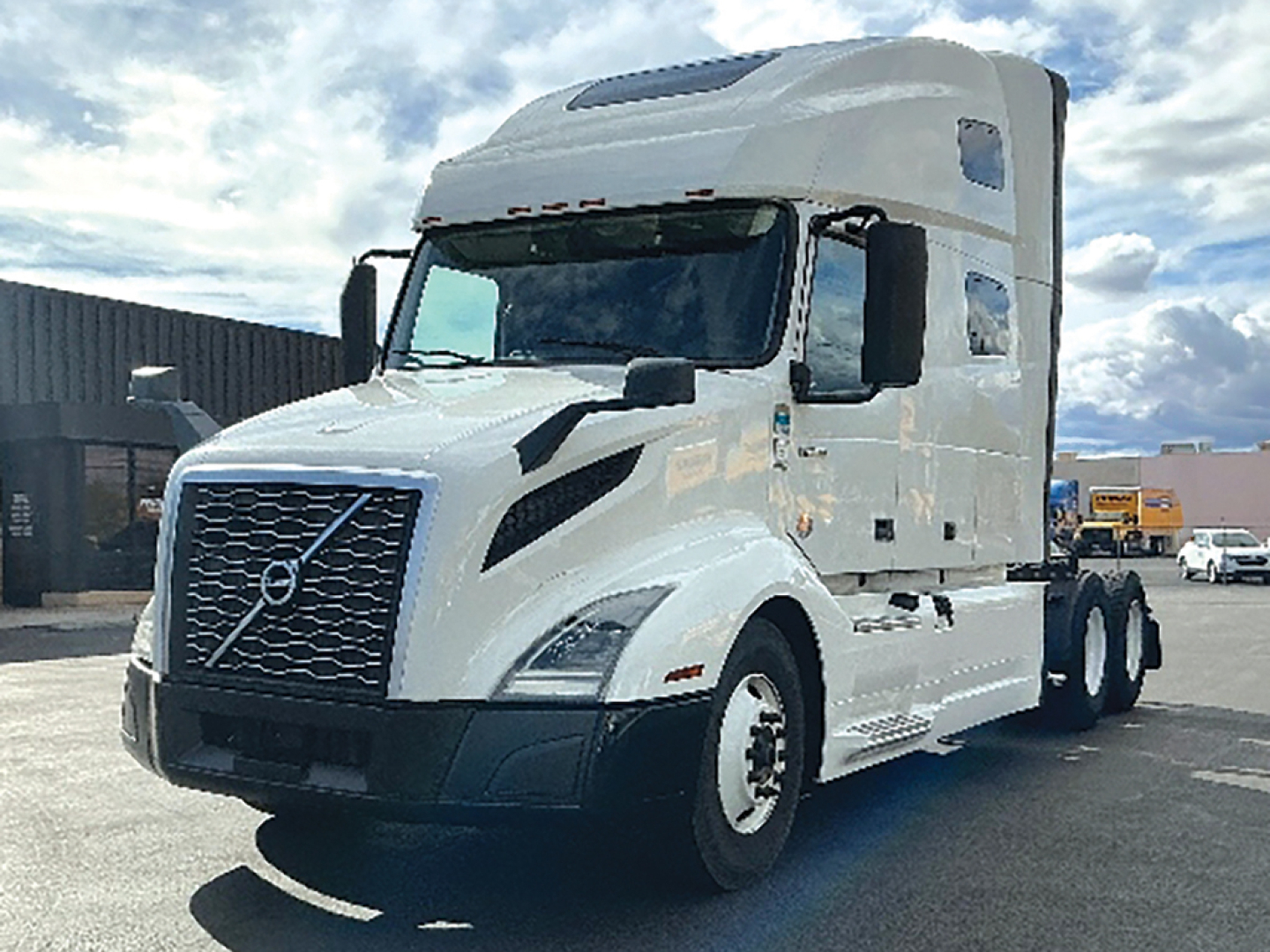 Volvo VNL 760 tractor-trailer cab with sleeper, white color, showing Volvo emblem on grille and side mirrors.