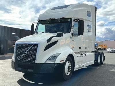 Volvo VNL 760 tractor-trailer cab with sleeper, white color, showing Volvo emblem on grille and side mirrors.