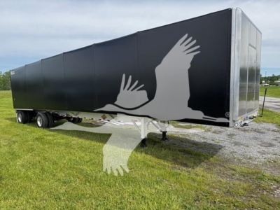 Trailer side showing large graphic of birds in flight and front end of Curtainside trailer with black exterior