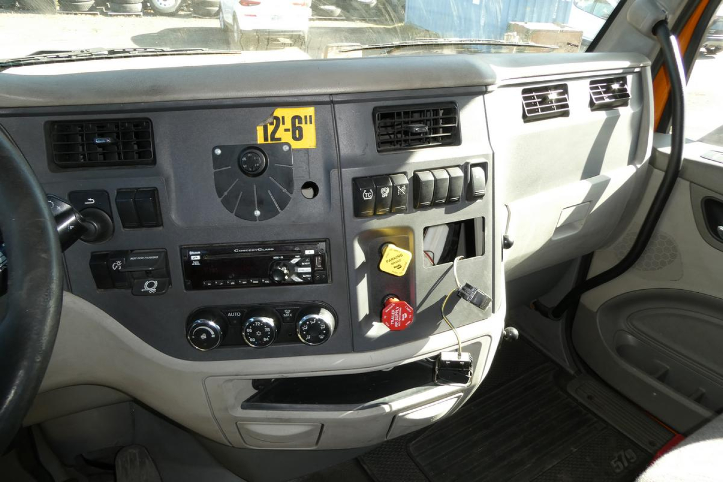 Peterbilt 579 dash close-up showing instrument cluster, control switches, and HVAC vents in a daycab truck interior.