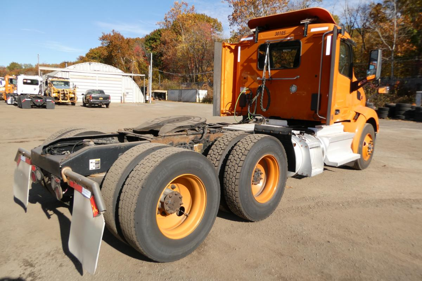 Peterbilt 579 conventional daycab rear view showing dual rear axles and orange paint with stock number 1023262 and VIN 1XPBD49X4MD736912.