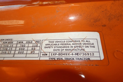 Vehicle label showing VIN 1XPBD49X-4MD736912 and safety standards text, with tire size and pressure chart partial visible.