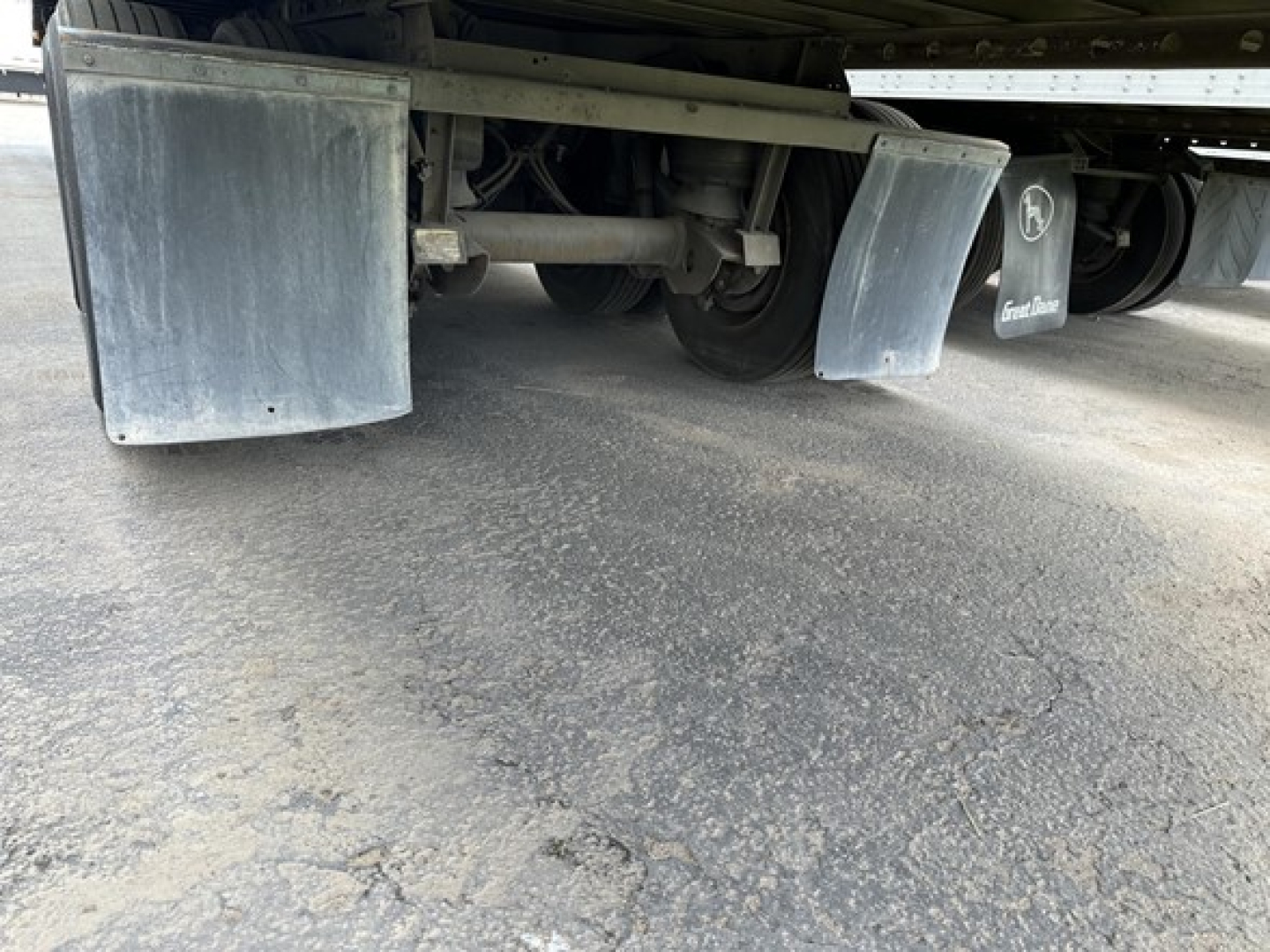 Trailer undercarriage showing dual mudflaps and axle components of a Utility 4000D-X trailer