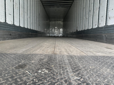 Inside view of a 2019 Utility 4000D-X trailer cargo space with wooden floor and metal side walls.