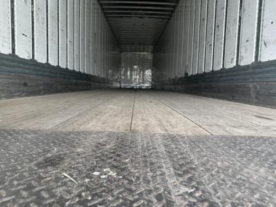 Trailer interior showing empty cargo area with wooden floor and metal walls, Utility 4000D-X model likely, long dark trailer interior perspective.