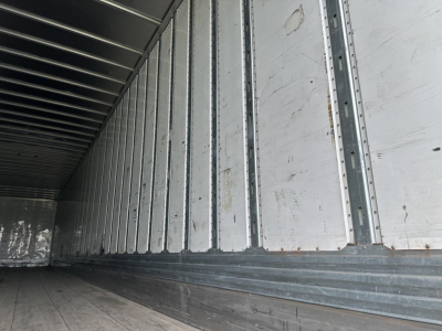Utility 4000D-X trailer interior with aluminum sidewalls and ribbed floor, showing metal joists along the walls.