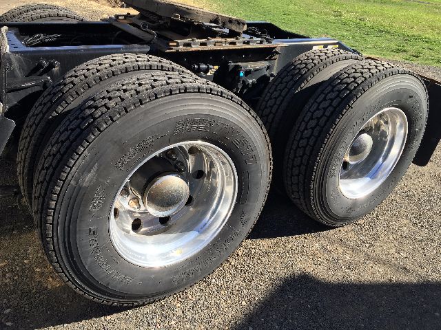 Dual rear wheel assembly of a Peterbilt truck showing two large tires with chrome rims.