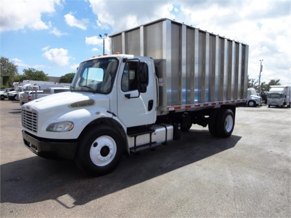 Freightliner BUSINESS CLASS M2 106 dump truck side view showing cab and large steel bed.