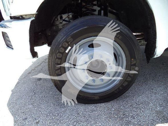 Ford F-550 wheel and front fender showing Goodyear 2002 tire and steel wheel, part of a dump truck.