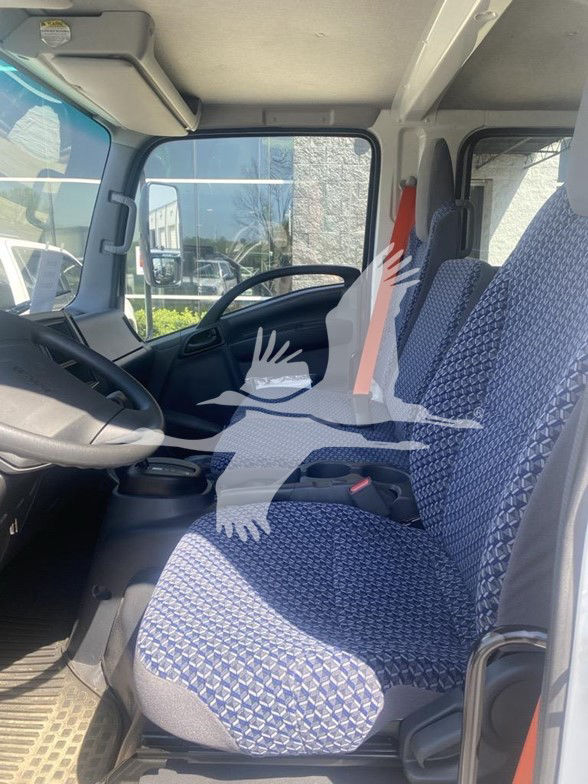 Isuzu NPR HD cab interior showing front seats, steering wheel, dashboard, and driver-side door with patterned gray fabric seats.