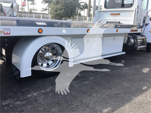 Peterbilt 337 chassis with white fenders and chrome wheels, side storage boxes, low-angle view.