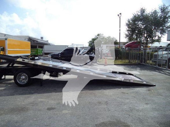 2014 Hino 258ALP tow truck with a lowered flatbed in an outdoor lot.