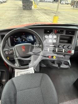 Kenworth T880 cab interior showing steering wheel and dashboard with control panels and gauges.