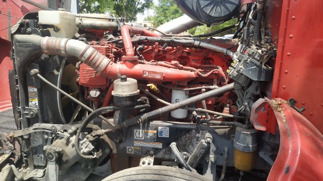 Peterbilt 386 engine bay showing red diesel engine with intake piping and auxiliary components.