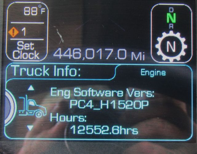 Truck dashboard display showing engine software version PC4_H1520P and hours 12552.6 with 446,017.0 miles and gear indicator in N.