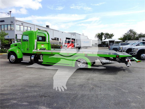 2022 Peterbilt 337 tow truck side view showing bright green cab and tow bed with chrome wheels.