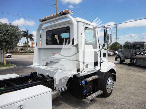 Truck cab side view showing chrome steps, side mirror, and white body. Tow truck flatbed area visible with rear compartment.