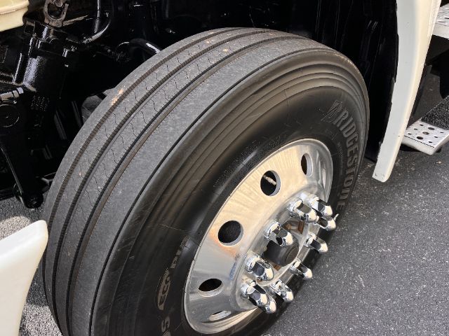 Tire and wheel on a Freightliner Cascadia truck showing Bridgestone tire and polished steel hub with lug nuts.