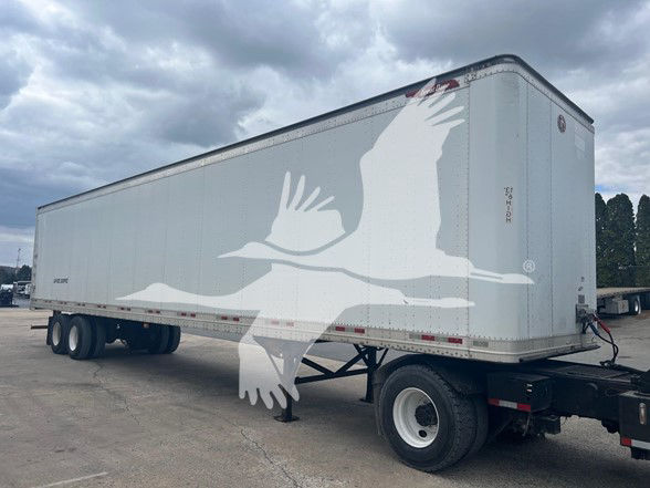 Great Dane sheet and post roll door trailer showing white graphic on gray body and dual rear axles.
