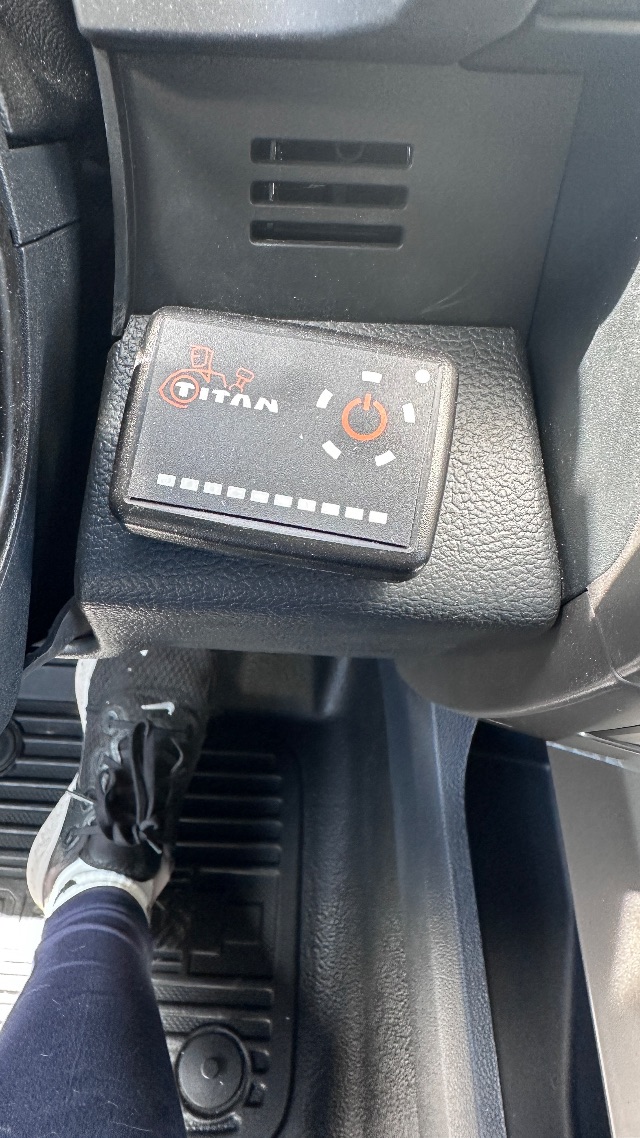 Ford F-550 interior with Titan switch box and circular power control, located near lower dash, with vent slits above and driver footwell visible.