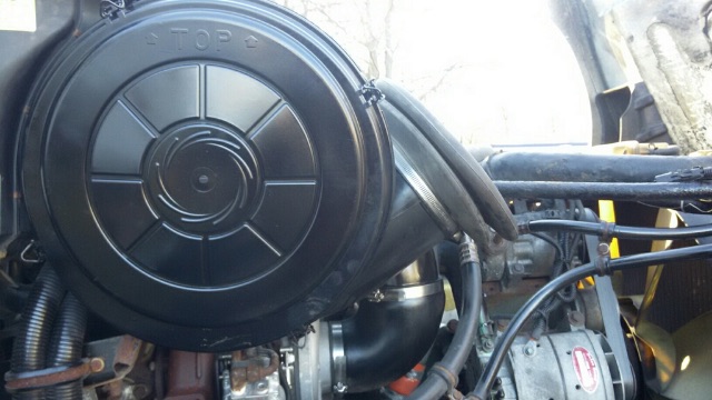Freightliner Columbia truck engine bay showing air intake housing and surrounding hoses and components.