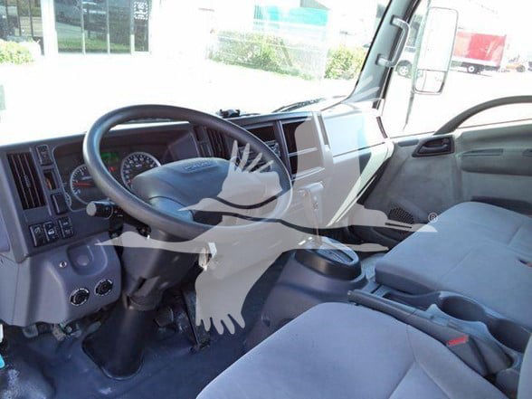 Isuzu NRR truck interior showing steering wheel, dashboard with gauges, and front seats.