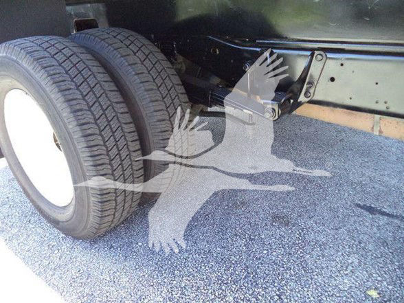 Ford E450 chassis showing dual rear wheels and undercarriage components.