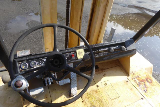 Caterpillar V225 truck-mounted forklift dashboard and steering wheel with pedals and control levers visible.