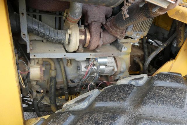 Komatsu/Bomag BW212D-2 engine compartment showing turbocharger, hoses, wires, and metallic components.