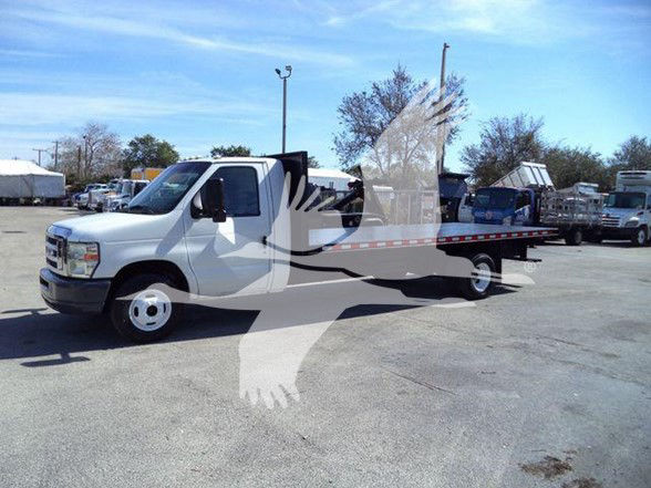 Ford E-450 flatbed tow truck side view showing front cab and long flatbed with reflective tape.