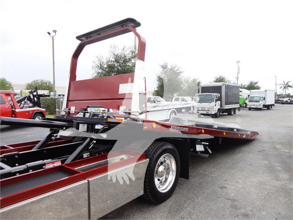 2022 Peterbilt 337 tow truck flatbed with hydraulic dovetail and wheel, side view showing flatbed and red chassis.