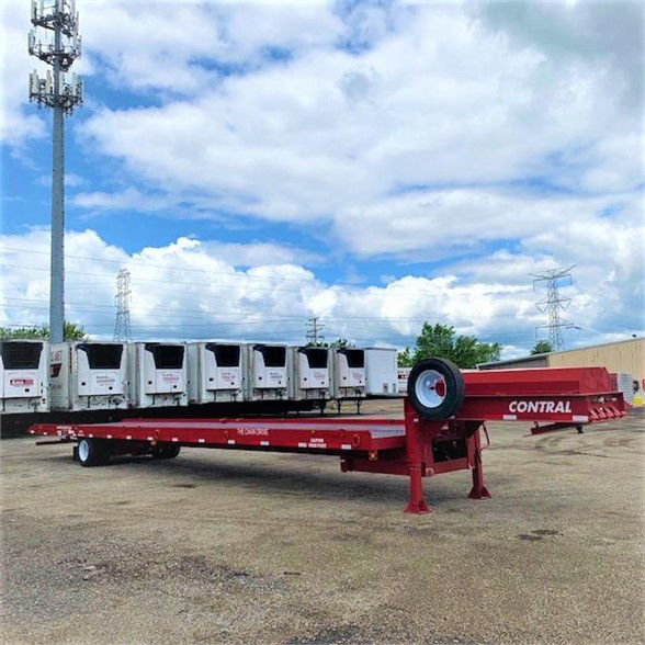 Red drop deck trailer with flatbed, single axle, and spare wheel on side; brand 'CONTRAL' on frame; multiple container trailers in background.