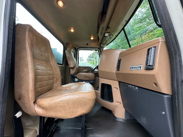 Truck cab interior showing two brown seats and dashboard with Granite badge in a 2017 Mack GU713 vacuum truck.