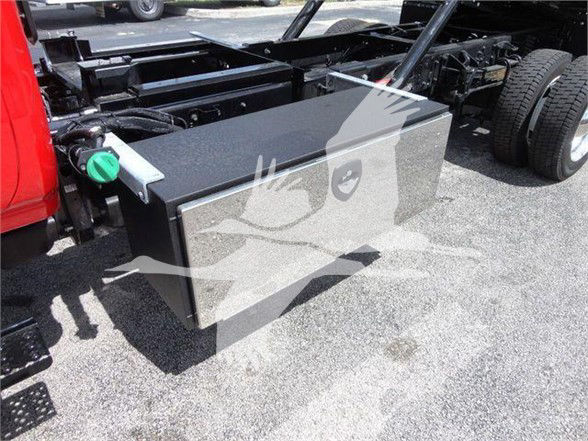 Rectangular metal fuel tank or storage box mounted on the chassis of a new International CV truck chassis with green cap visible.