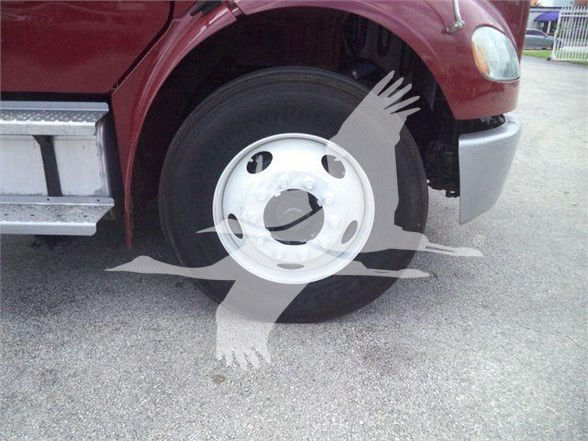 Freightliner BUSINESS CLASS M2 106 front wheel and fender area with white wheel cover visible.
